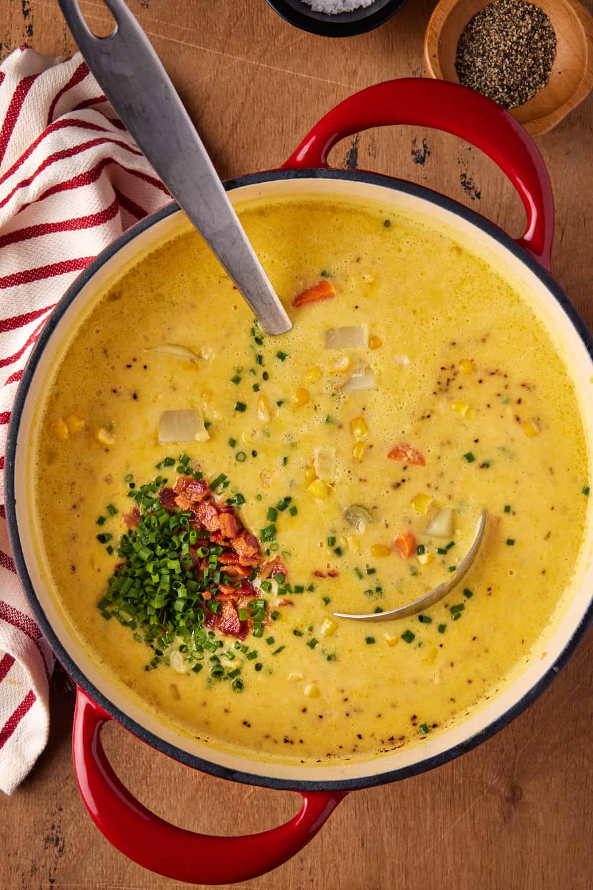 Red dutch oven pot filled with potato corn chowder. 