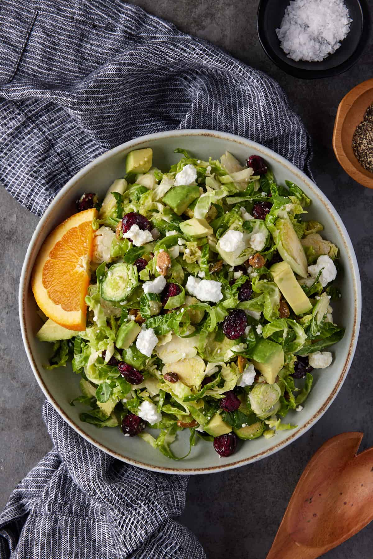 Gray bowl filled with brussels sprouts salad with a gray striped napkin. 