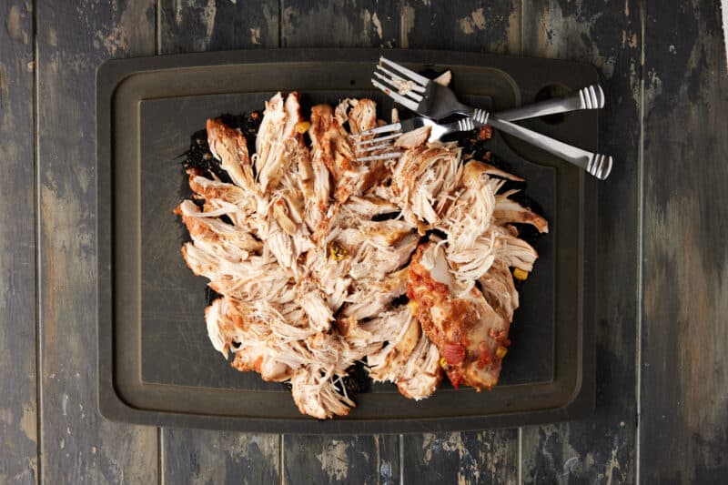 shredded chicken breasts on cutting board.