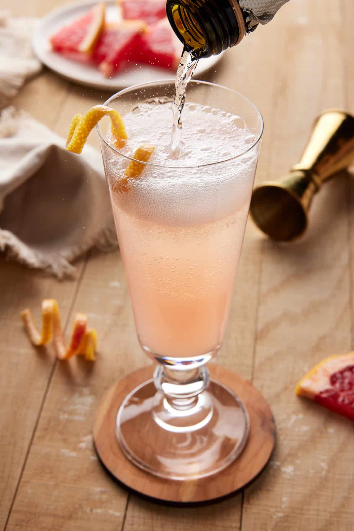 Sparkling wine poured into fluted glass with grapefruit juice. 