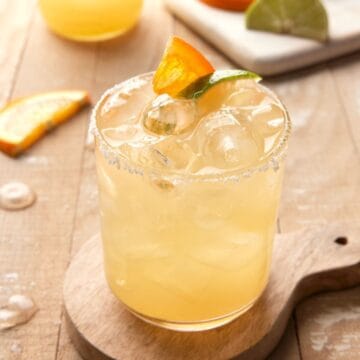 Margarita on ice with orange wedge.