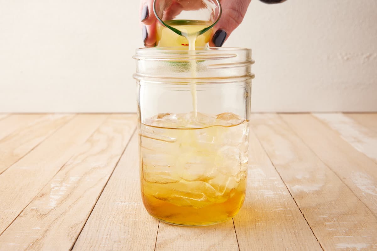 Orange juice being poured into shaker.