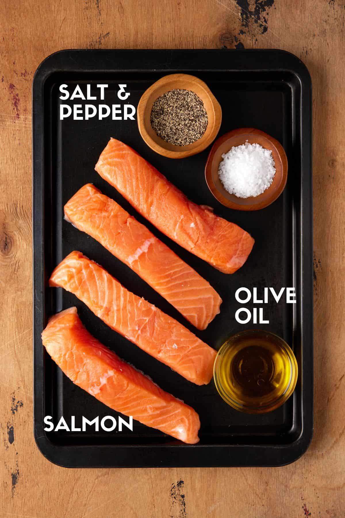 Raw salmon cuts on a sheet pan with olive oil, salt and pepper. 