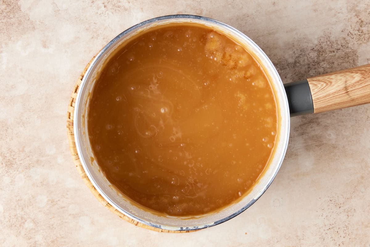 Bread pudding sauce in a white sauce pan. 
