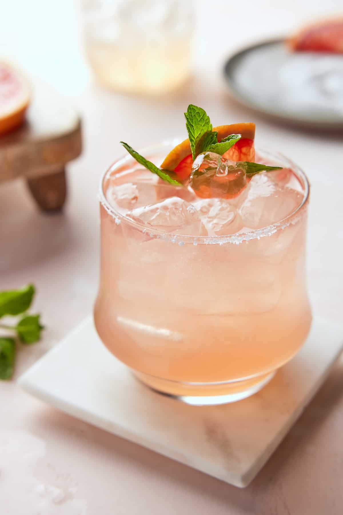 Salty Dog drink in low ball glass garnished with grapefruit wedge and mint.