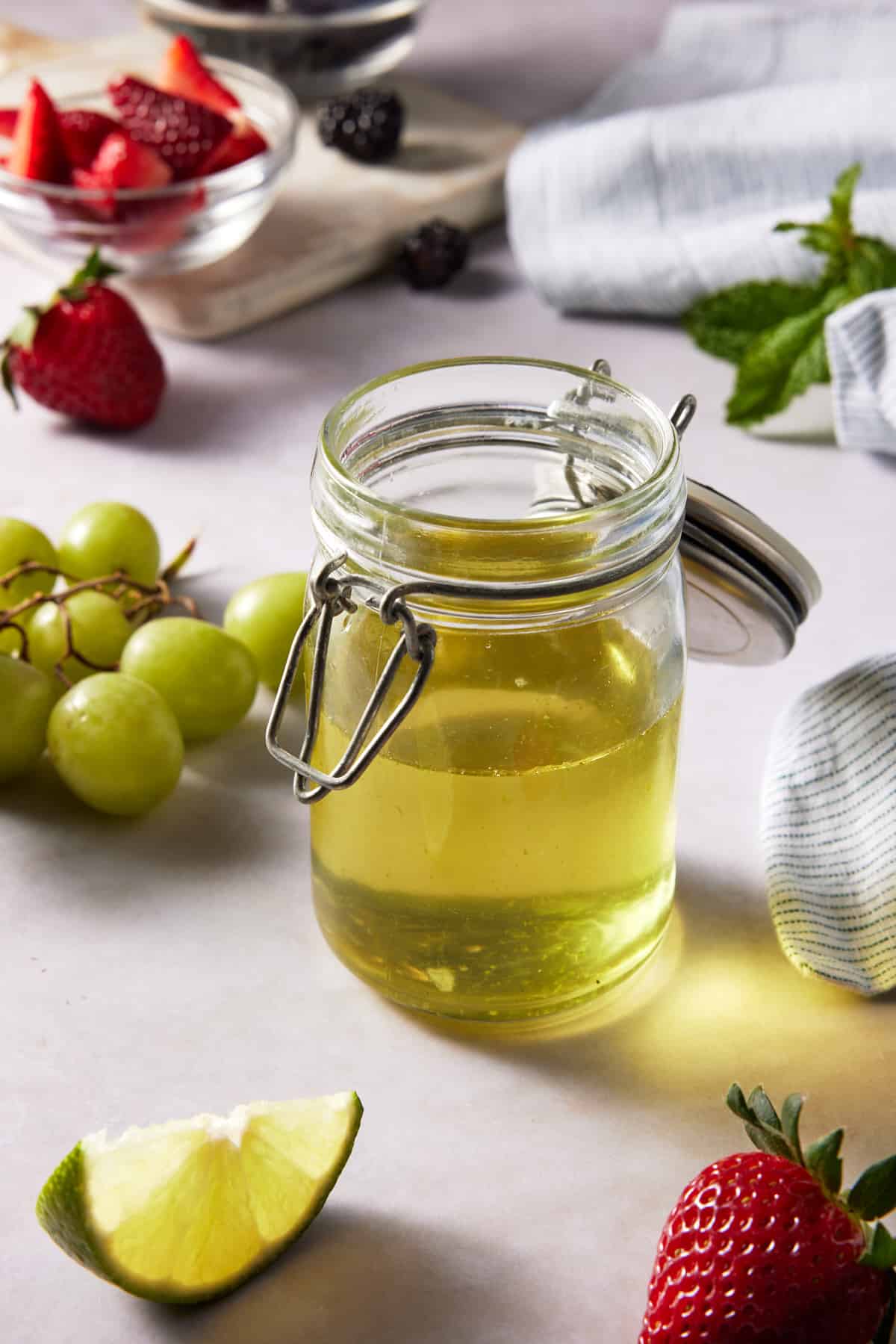 Lime mint fruit salad dressing in a glass jar with lid. 