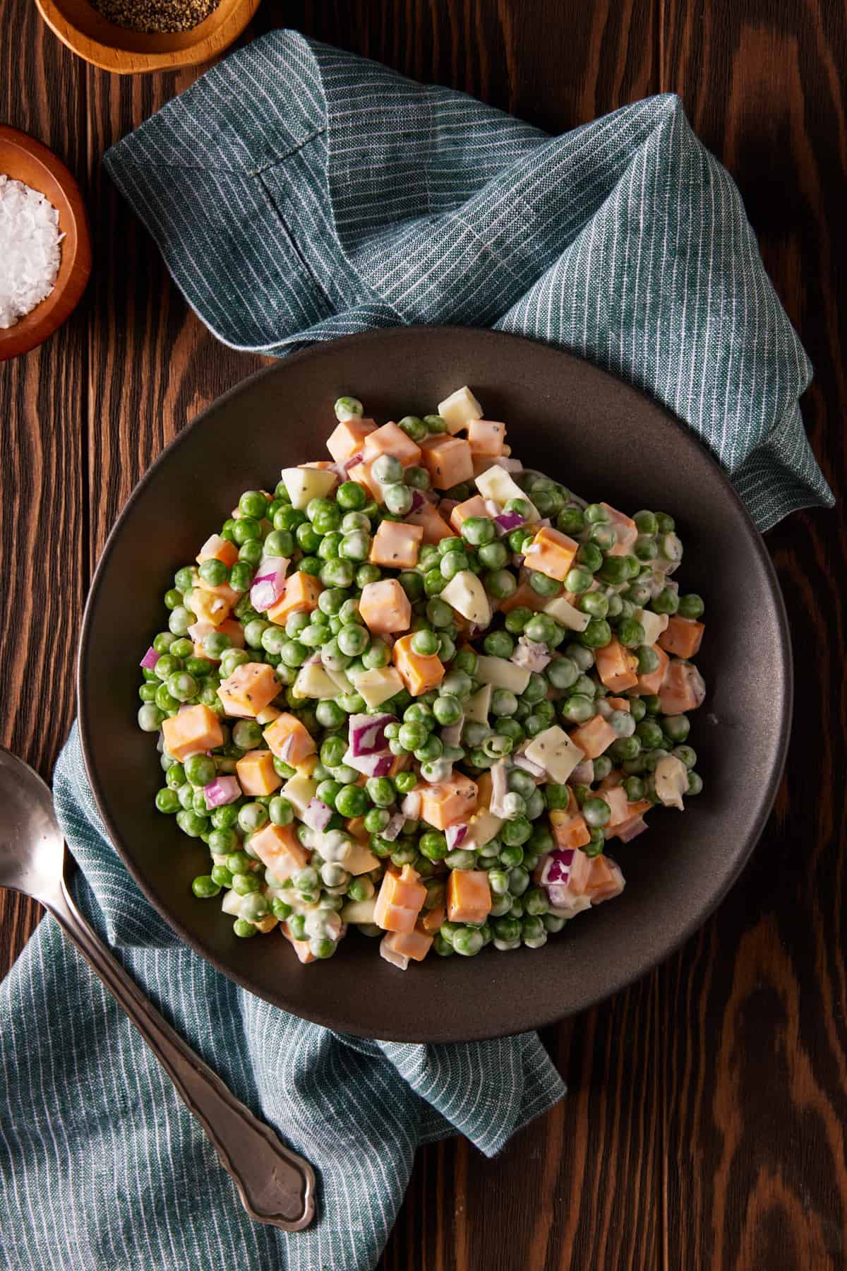 pea and cheese salad on a plate with a spoon.