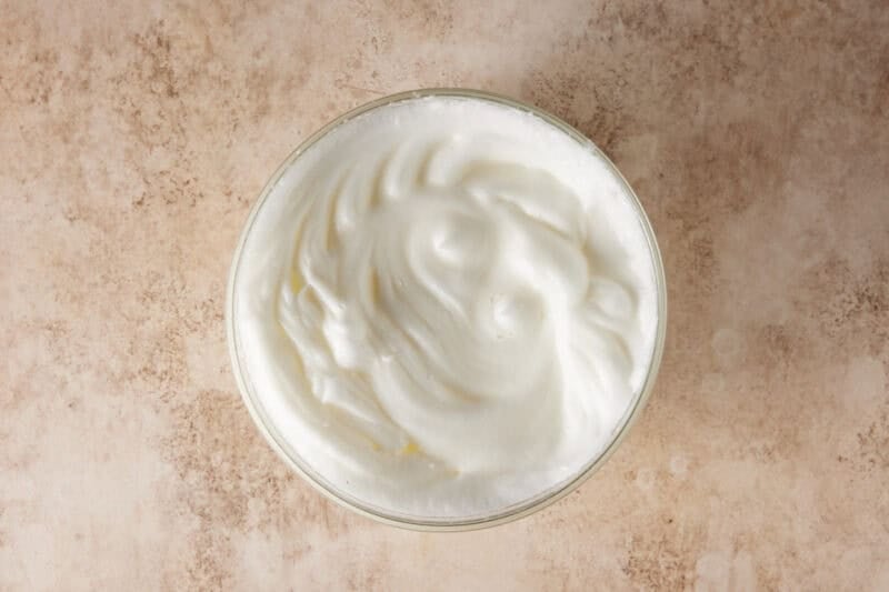 Beaten egg whites in a glass bowl. 