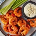Spicy shrimp tossed in buffalo sauce with condiments.