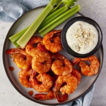 Buffalo shrimp on plate with condiments for dipping.