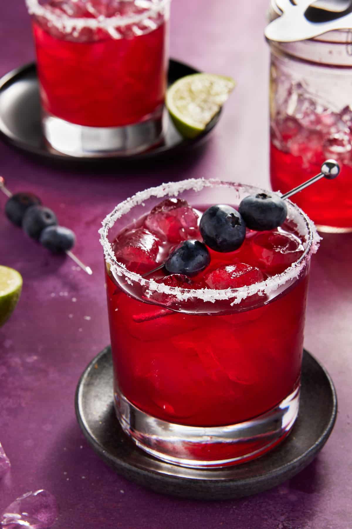 Blueberry margarita in low ball glass with salted rim.