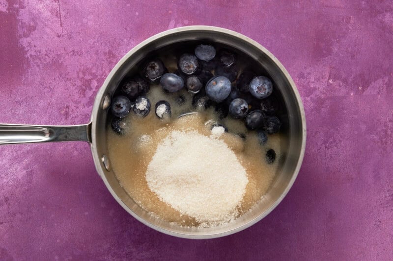 Blueberries, water and sugar in a pan.