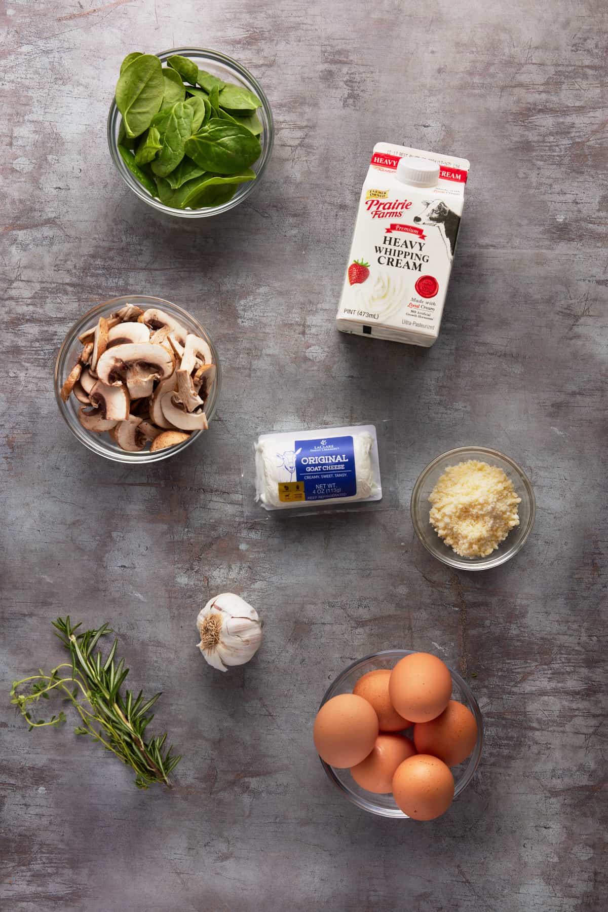 Ingredients in bowls for a goat cheese and spinach frittata