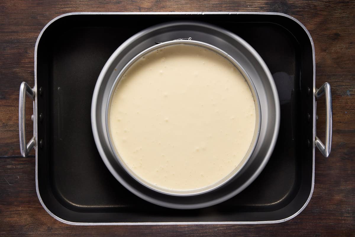 Cheesecake batter in a springform pan placed in a water bath. 