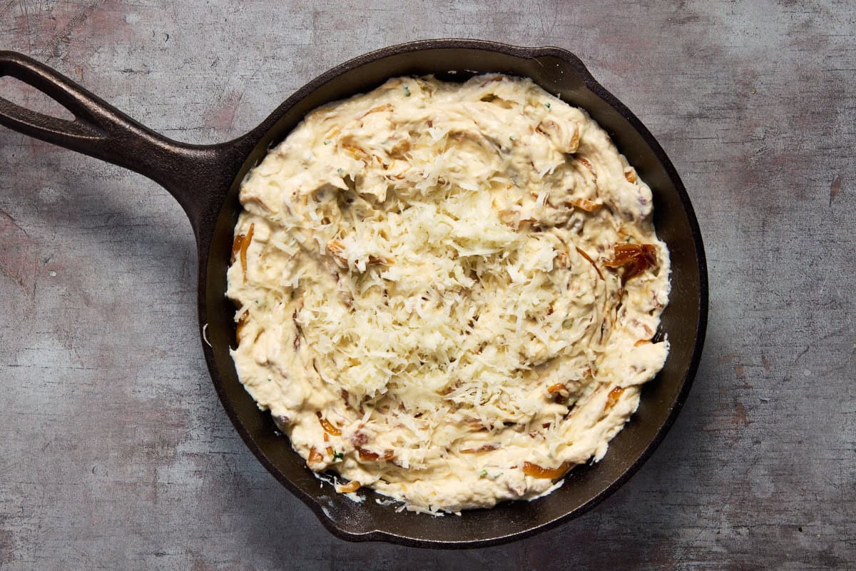Onion dip ready to be baked in cast iron.