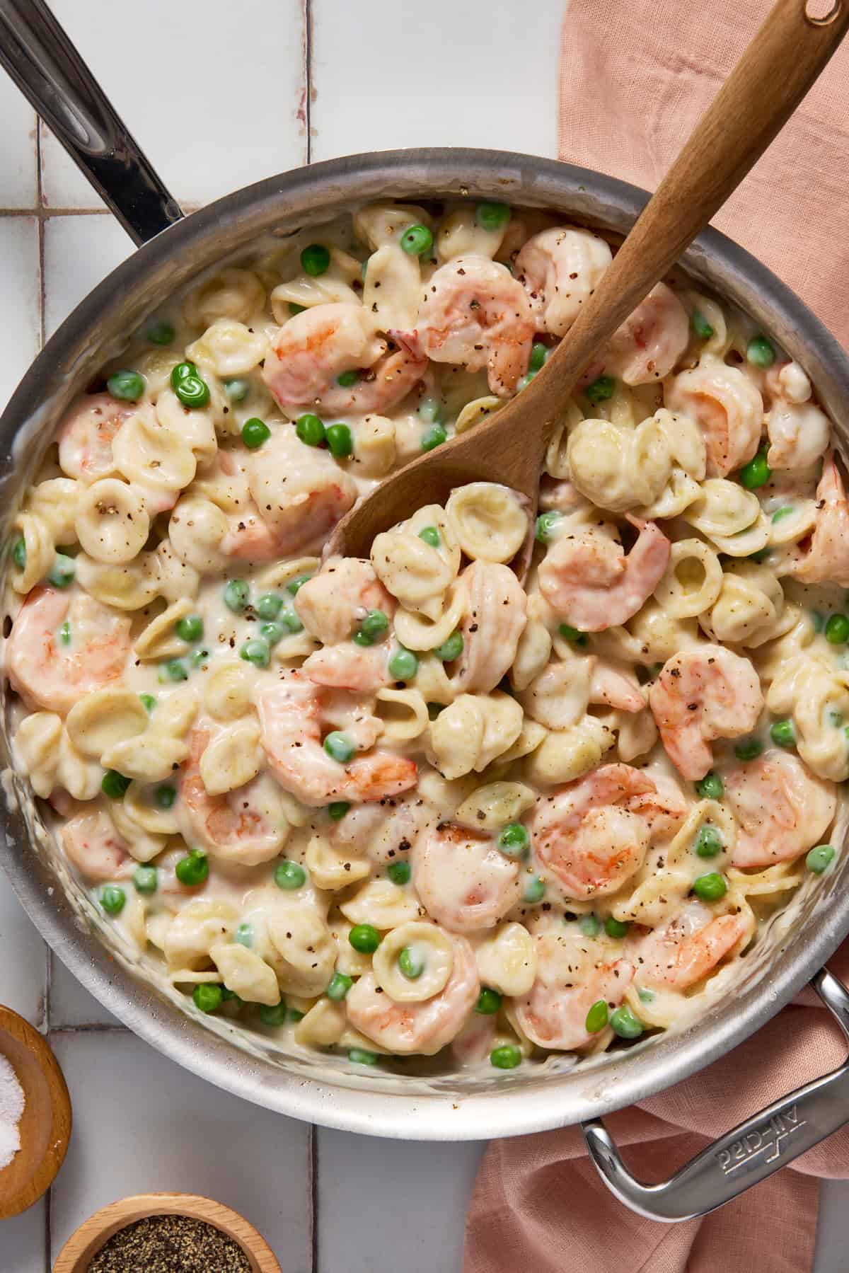 Creamy shrimp pasta with peas in a large skillet.