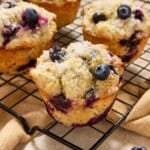 Blueberry Lemon Poppy Seed Muffins on a black wire cooling rack.
