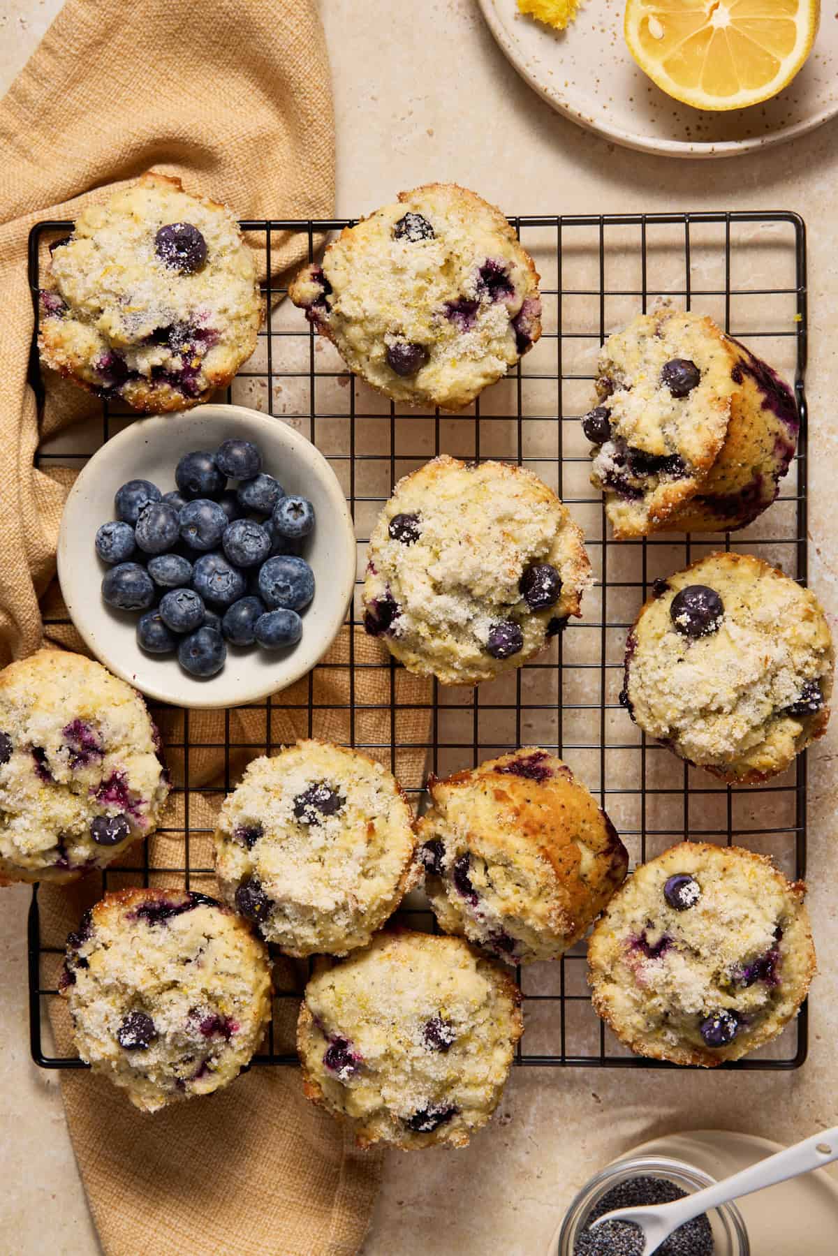 Blueberry Lemon Poppy Seed Muffins on a black wire cooling rack. 