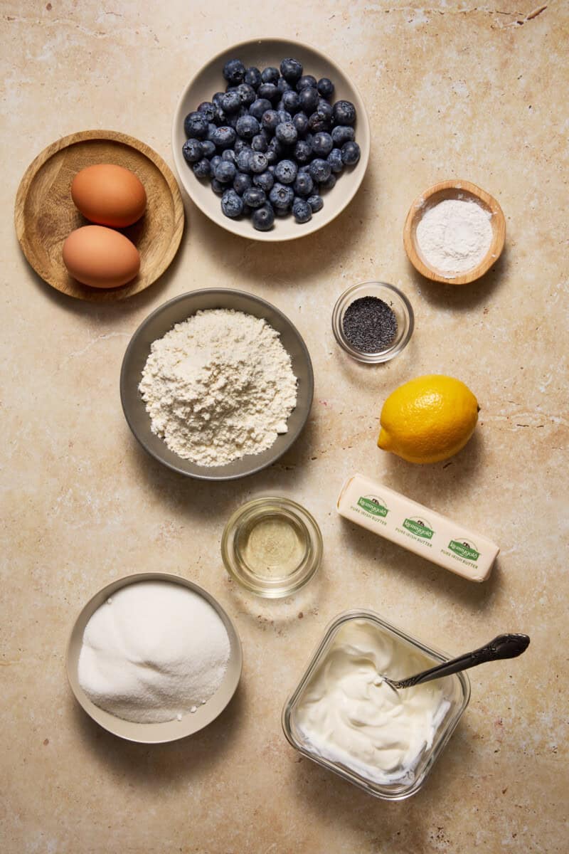 Blueberry Lemon Poppy Seed Muffin ingredients on a light wood board. 