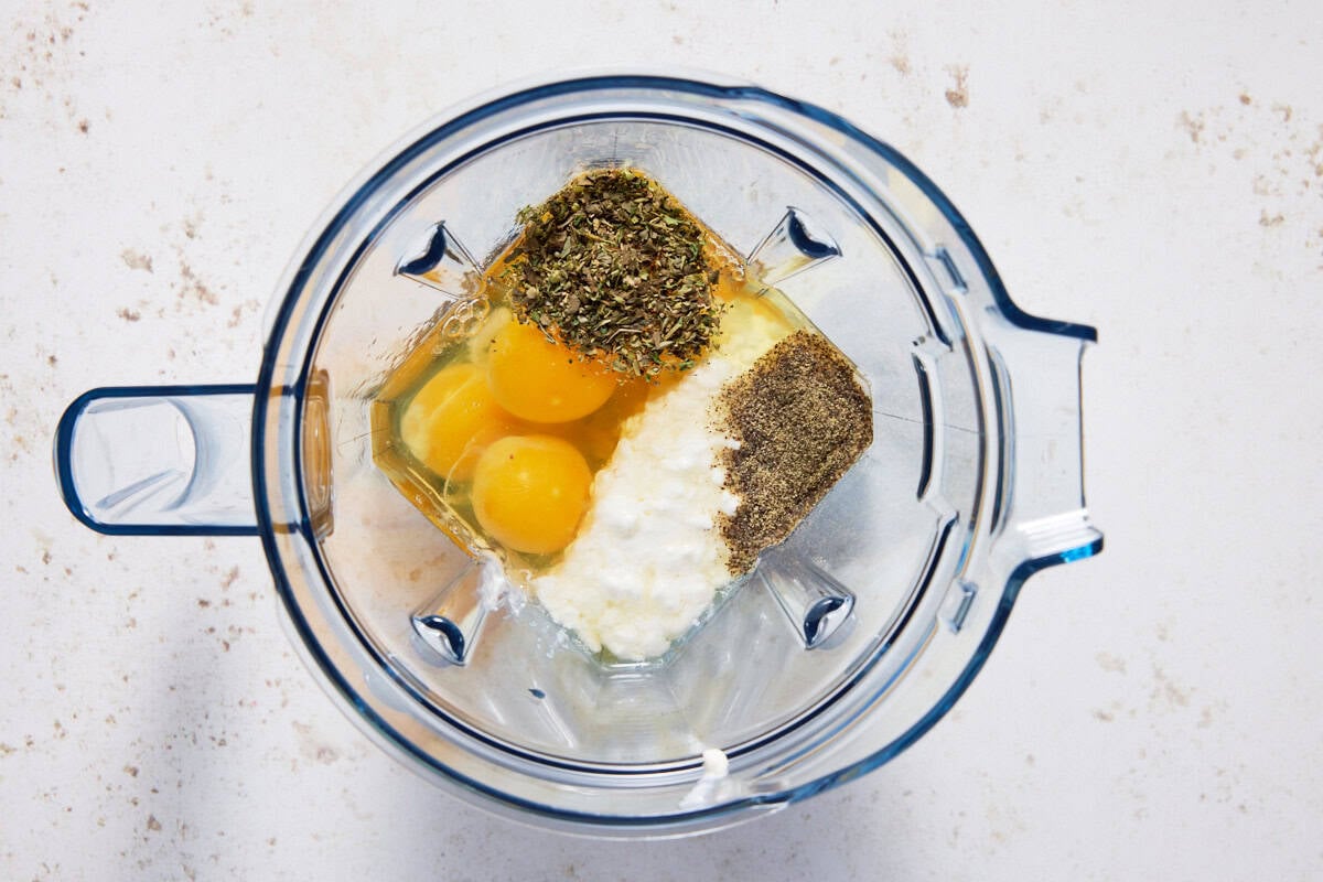 Eggs, cottage cheese, herbs and spices in a blender jar.
