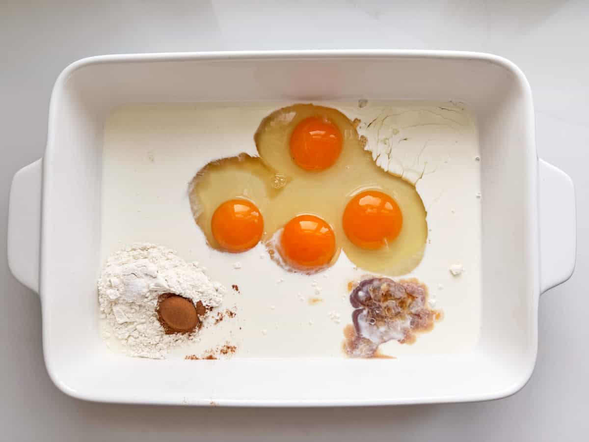 Eggs, cream and spices in a white casserole dish. 