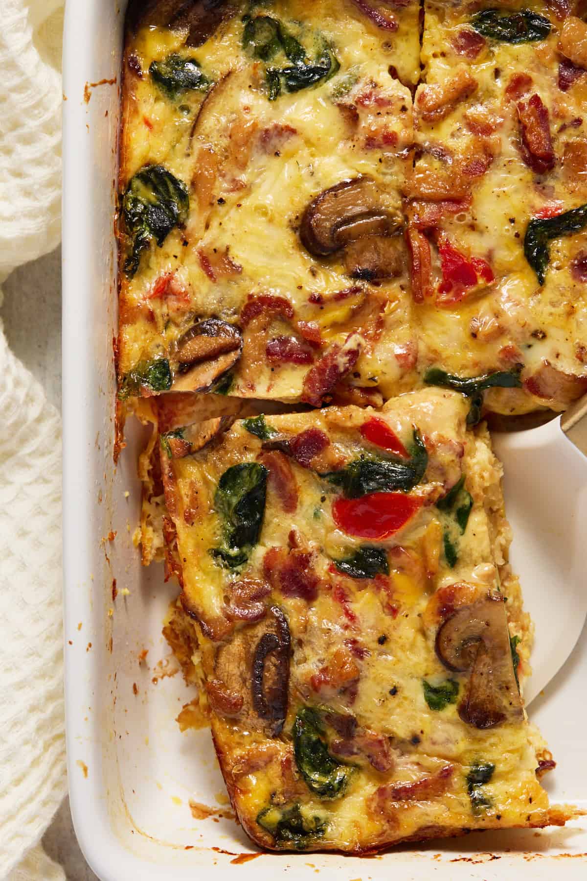 Lifter under slice of hash brown egg bake, ready to serve.
