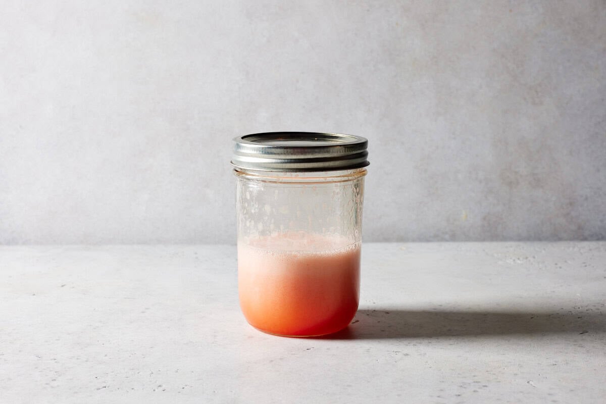 Foamy aperol sour in shaker.