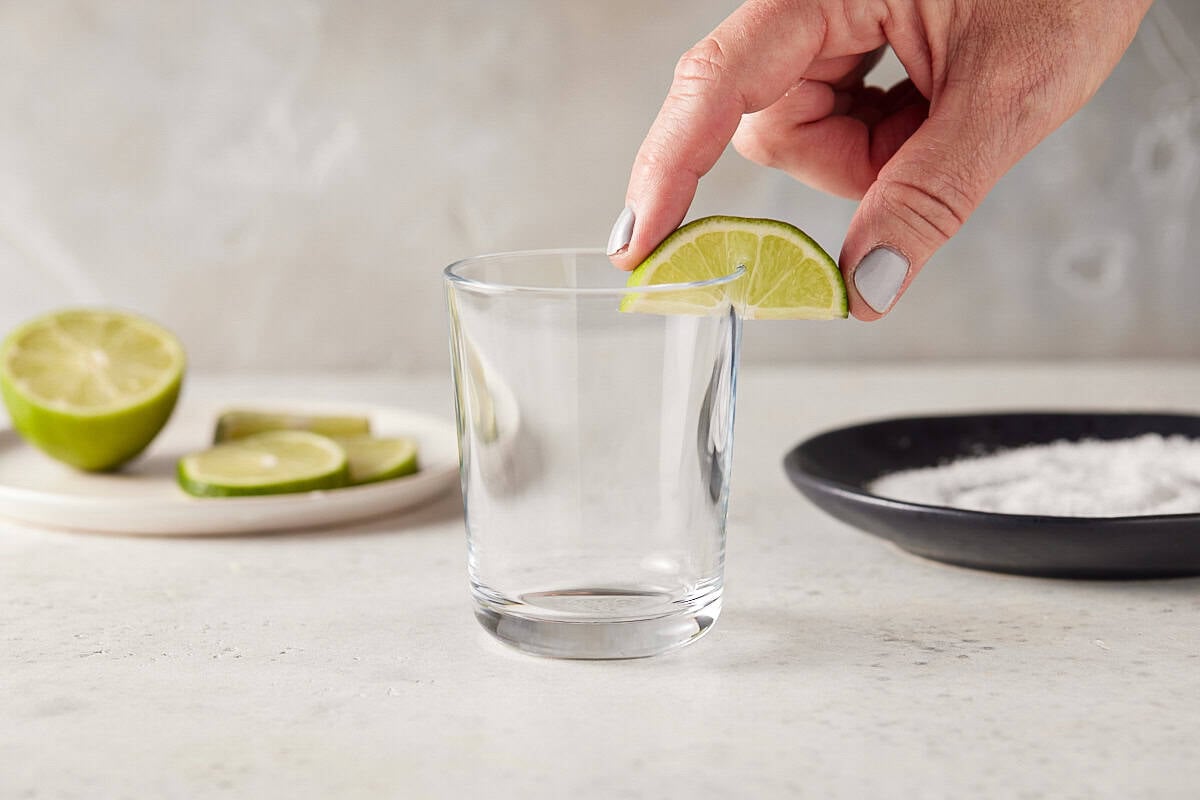 Rimming a glass with lime wedge.