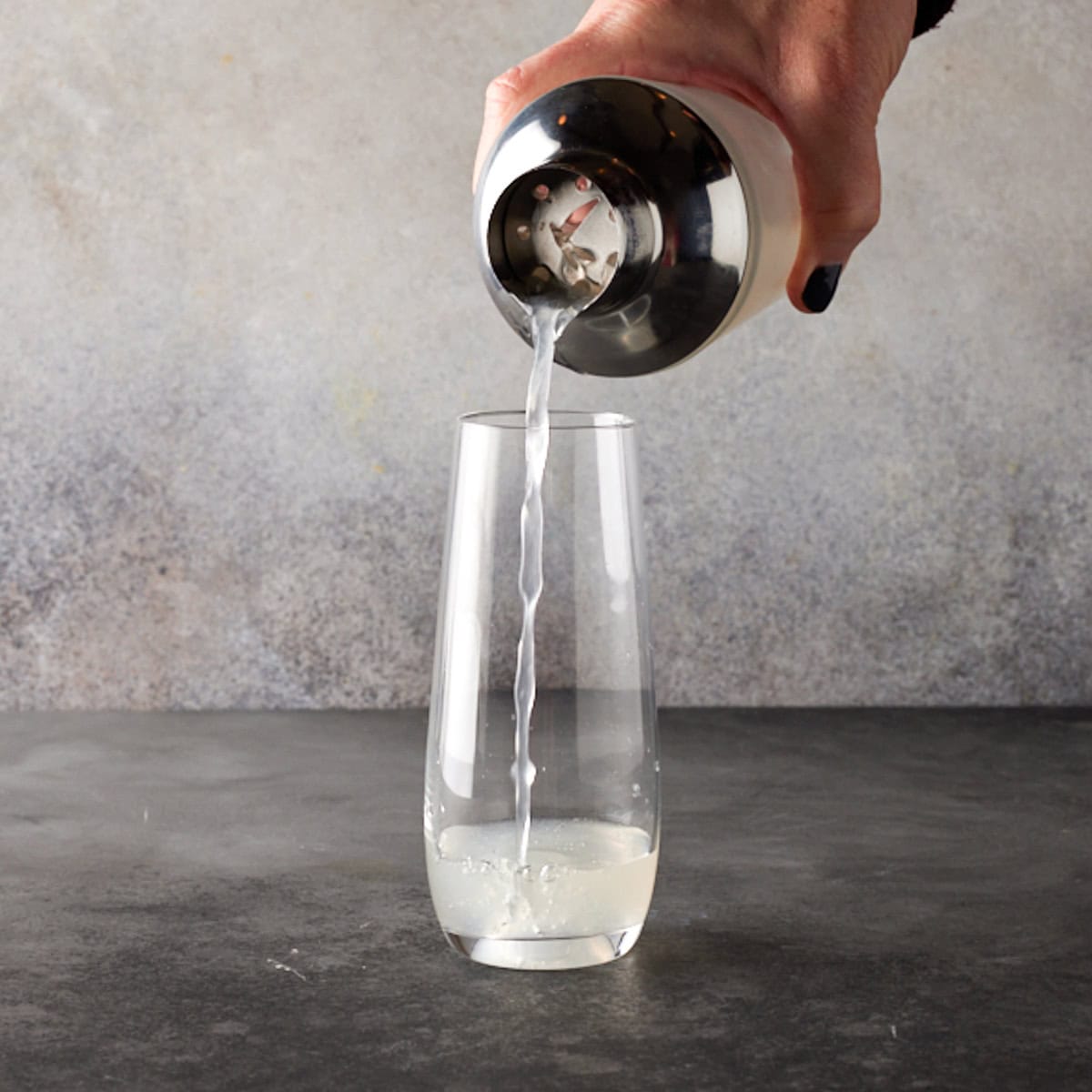 Cocktail. being poured into flute.