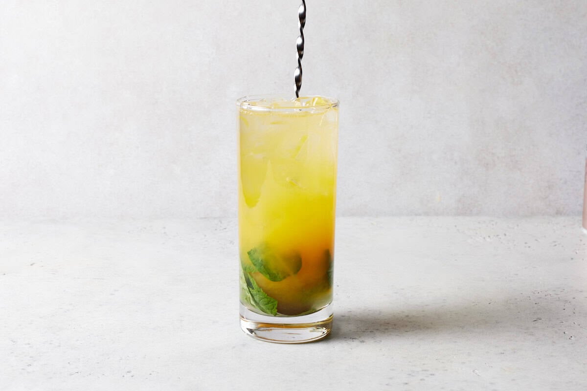 Mango mojito in high ball glass with straw.