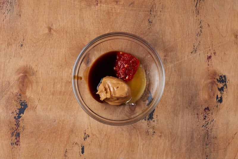 Peanut butter, chili sauce, and lime juice in bowl.