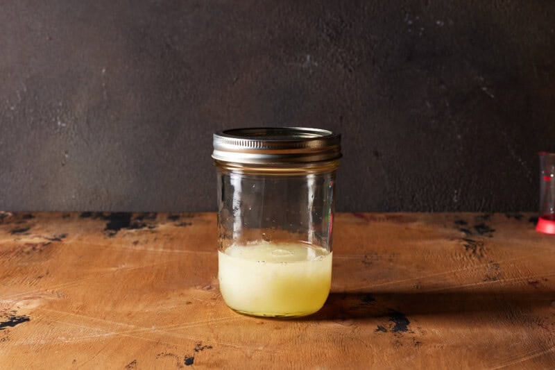 Shaker with ingredients for vodka sour in it ready to shake.