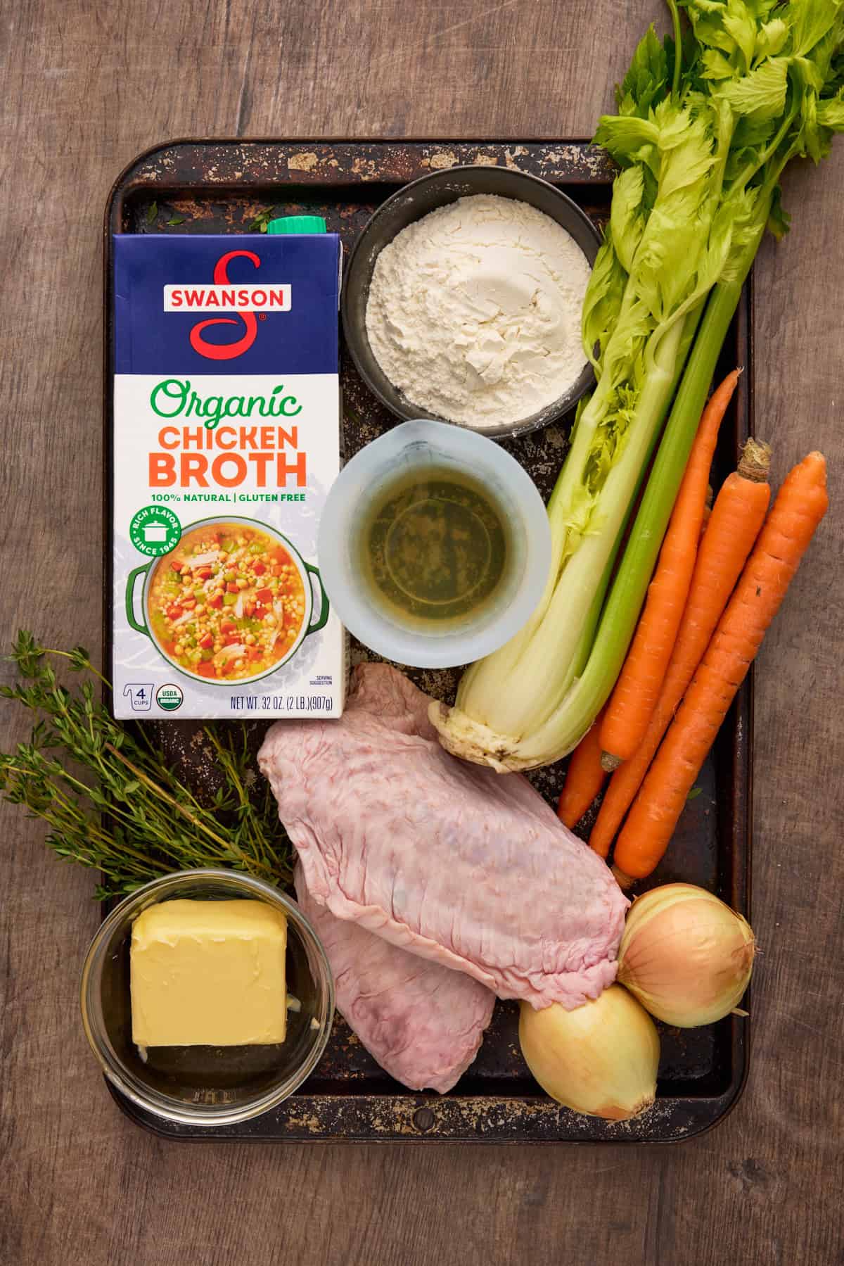 Chicken broth, white wine, flour, celery, carrots, turkey wings and fresh thyme-all of the ingredients needed for Make Ahead Turkey Gravy.