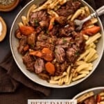 Two grey pottery bowls filled with beef daube (french beef stew) on a dark board with a brown napkin.