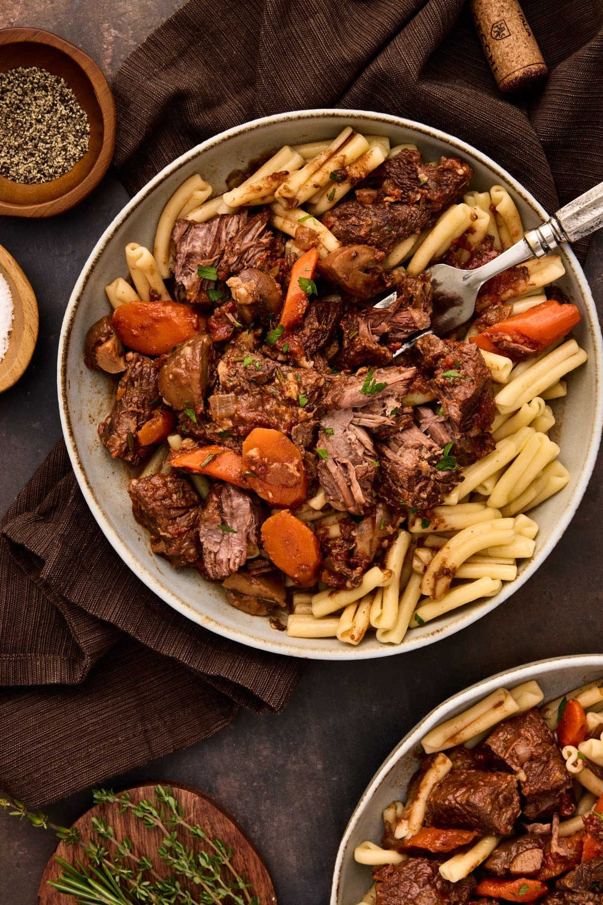 Two bowls of beef daube (french beef stew) in gray pottery bowls.