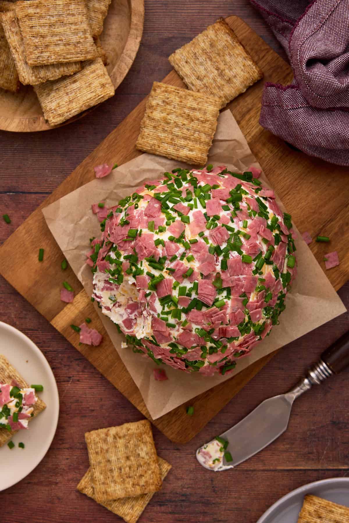 Top down image of garnished chipped beef cheese ball with triscuits.