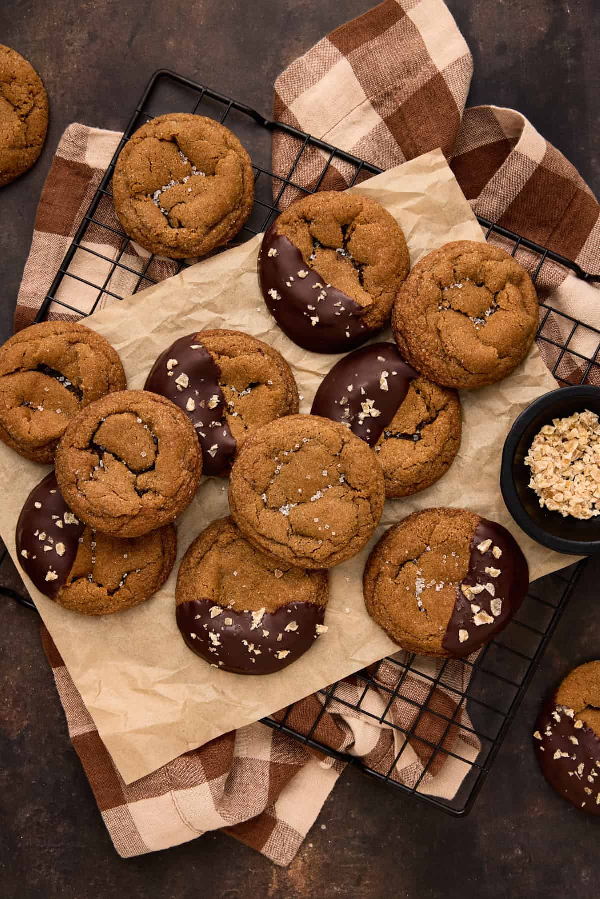 Chewy Ginger Molasses cookies, some dipped in chocolate with candied ginger and some plain with sugar sprinkles on cooling rack.