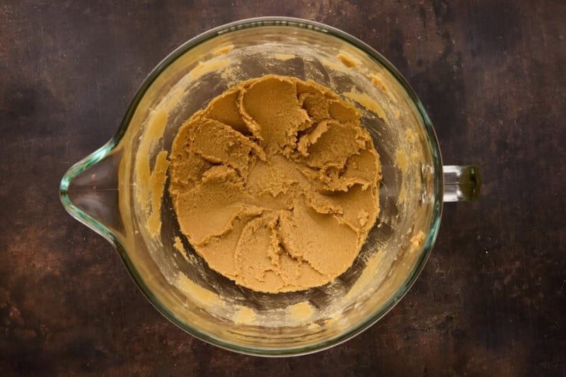 Creamed butter and sugars in glass mixing bowl.