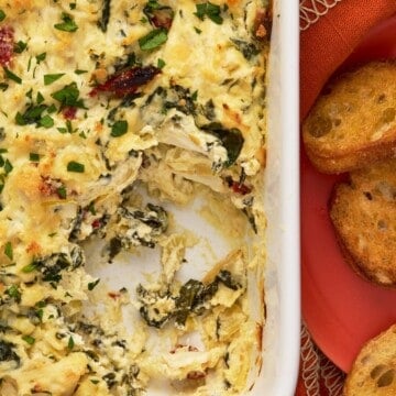 Crab dip in a white dish with crostini.