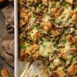 Top down view of mushroom and leek bread pudding in a white casserole dish.