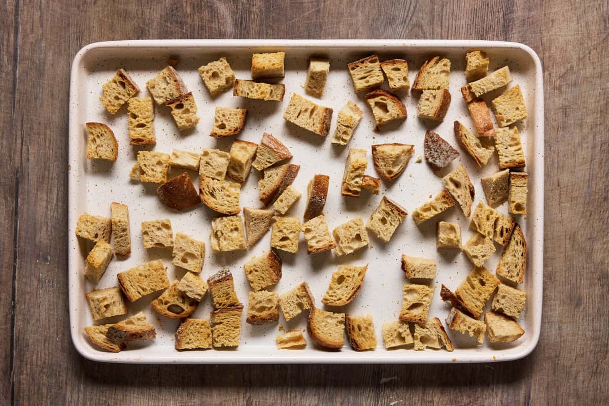 Toasted bread cubes on a sheet pan.