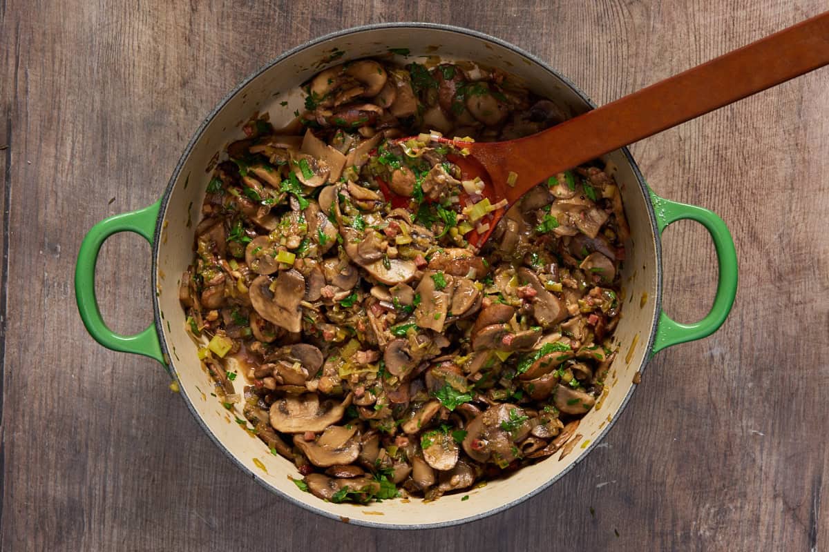 Green dutch oven with sauteed mushrooms, leeks and pancetta.
