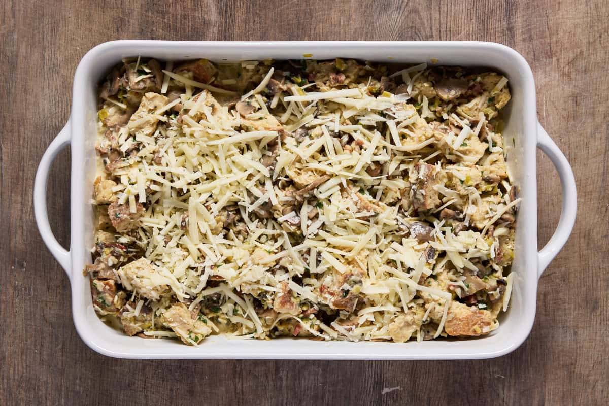 Raw cheese sprinkled on a mushroom & leek bread pudding.