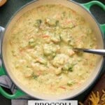 Broccoli Cheddar soup in a green ditch oven with a ladle ready to serve.
