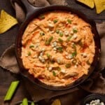 Buffalo chicken dip with blue cheese in a cast iron pan.