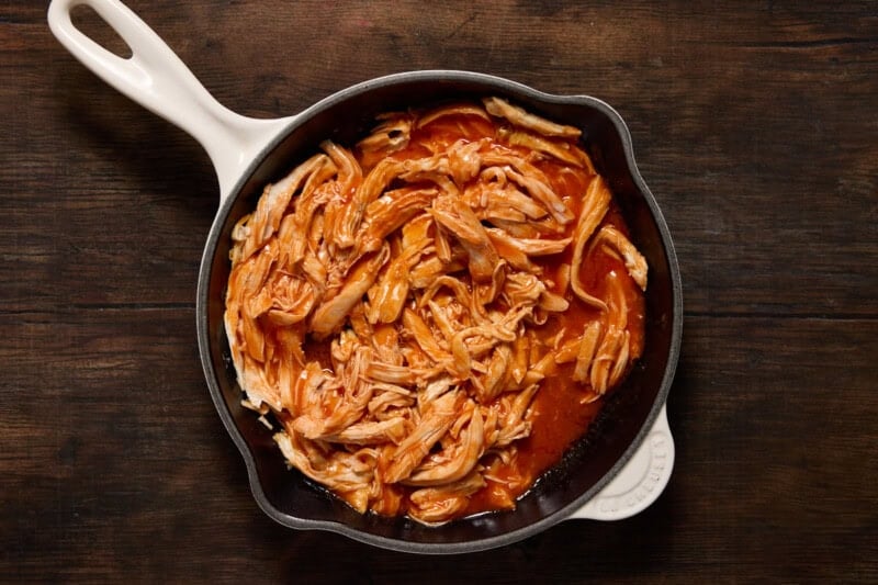 Shredded Chicken and Franks Red Hot sauce in a pan.