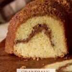 Sliced cinnamon swirl sour cream coffee cake on a wooden cutting board.
