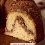 Sliced cinnamon swirl sour cream coffee cake on a wooden cutting board.