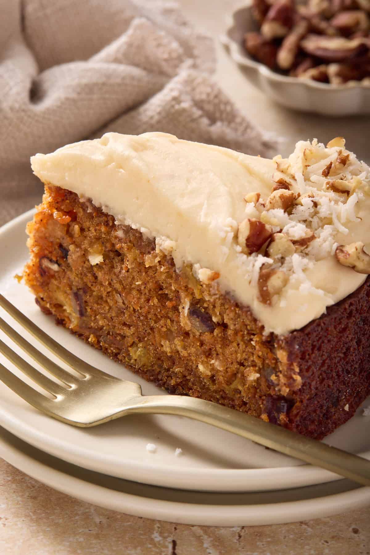 Close up picture of a slice of single layer carrot cake topped with brown butter cream cheese frosting.