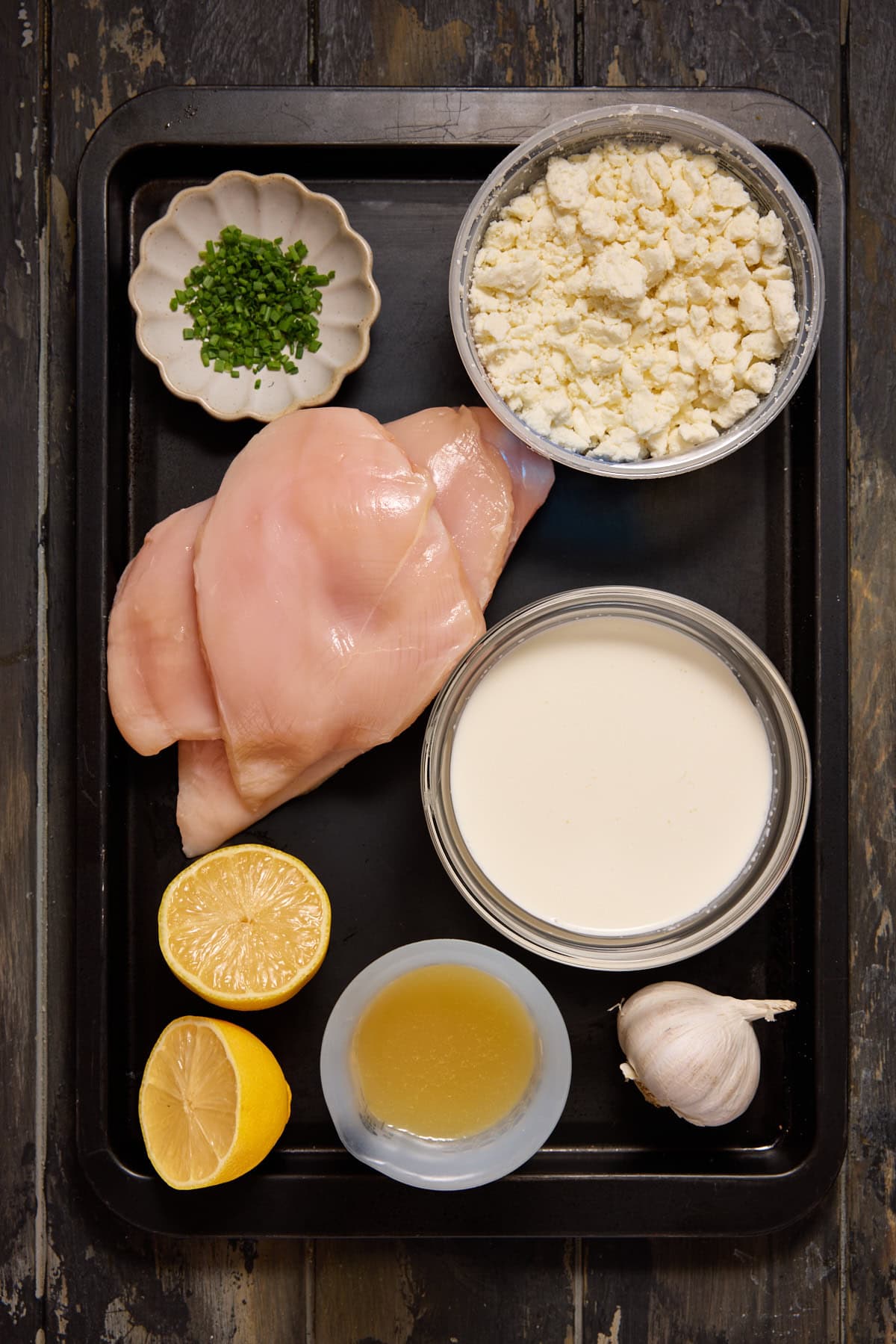 Chicken, feta cheese, chives, garlic and cream on a sheet pan.